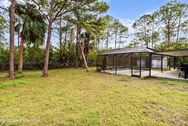 view of yard with a lanai, a patio area, and an empty pool