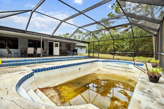 view of swimming pool featuring glass enclosure and a patio area