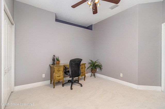 carpeted office space featuring ceiling fan