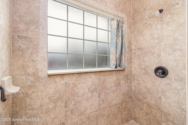 interior details featuring a tile shower