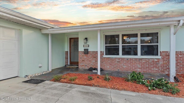 exterior entry at dusk featuring a garage