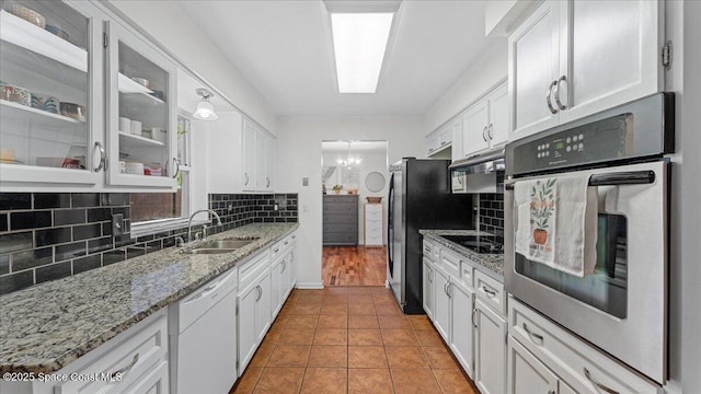 kitchen with sink, white cabinetry, light tile patterned floors, and stainless steel appliances