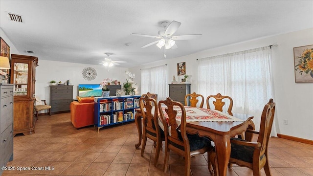 tiled dining space featuring ceiling fan and a textured ceiling