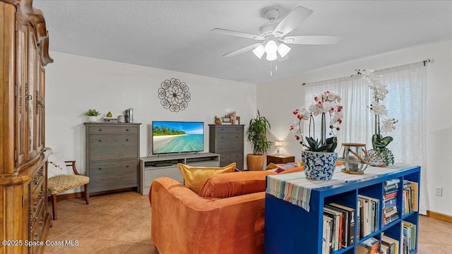 living room with ceiling fan, light tile patterned floors, and a textured ceiling