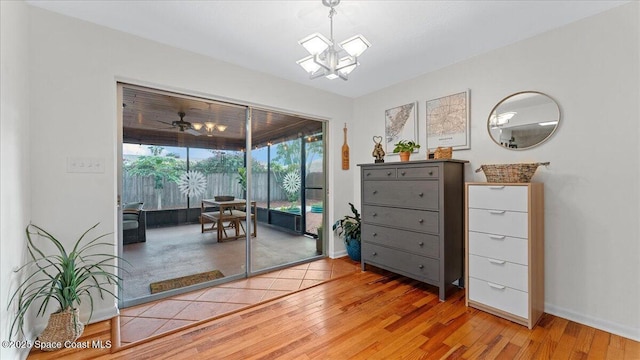 interior space featuring ceiling fan with notable chandelier and hardwood / wood-style flooring