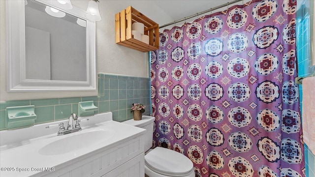 bathroom with tile walls, toilet, vanity, and a shower with shower curtain