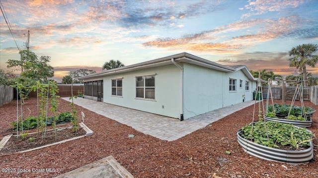 property exterior at dusk featuring a patio area