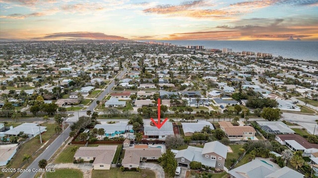 aerial view at dusk featuring a water view