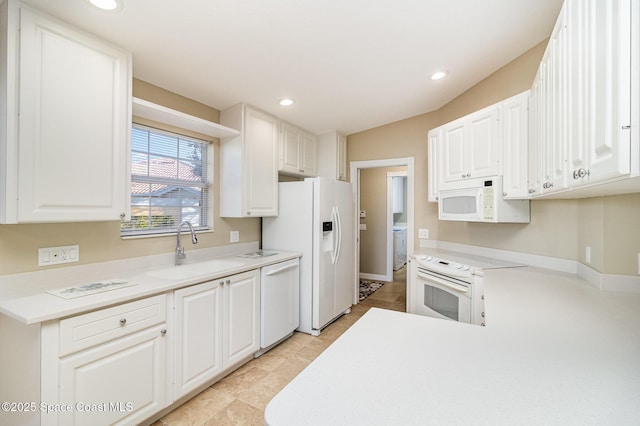 kitchen with white appliances, white cabinets, and sink