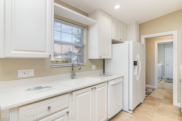 kitchen featuring sink, white appliances, and white cabinets