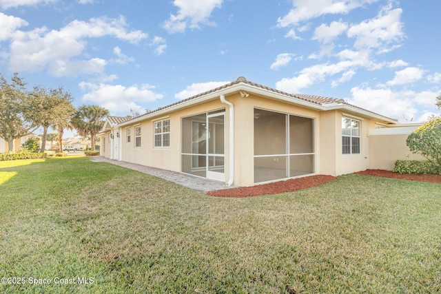 view of side of home with a lawn and a sunroom