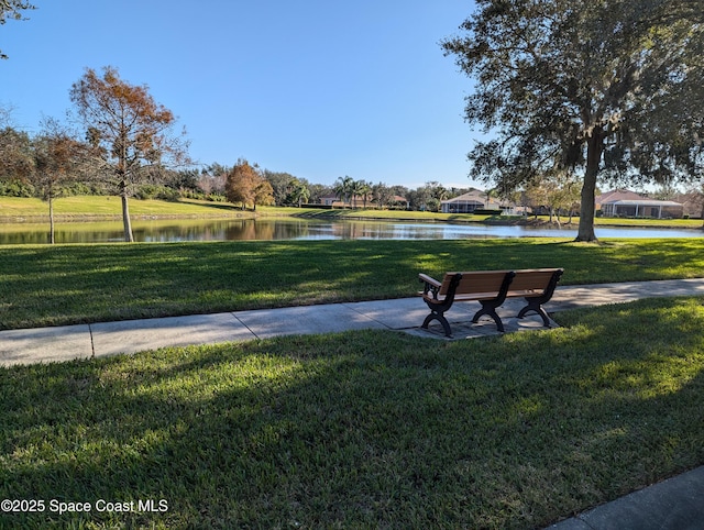 surrounding community with a lawn and a water view