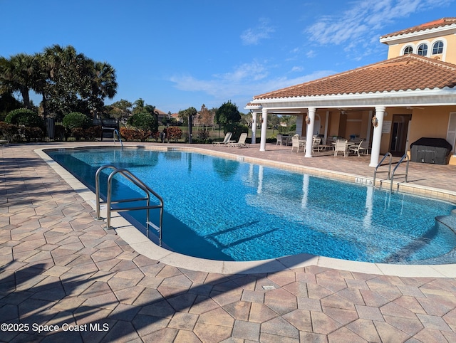 view of swimming pool featuring grilling area, a patio, and ceiling fan