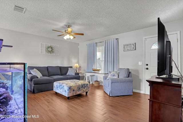 living room with a textured ceiling and ceiling fan