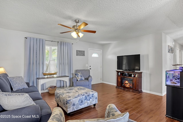 living room with a textured ceiling, ceiling fan, and hardwood / wood-style floors