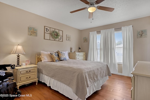 bedroom with ceiling fan and a textured ceiling