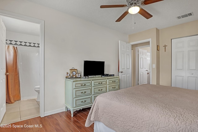 bedroom featuring a textured ceiling, a closet, ensuite bathroom, and ceiling fan