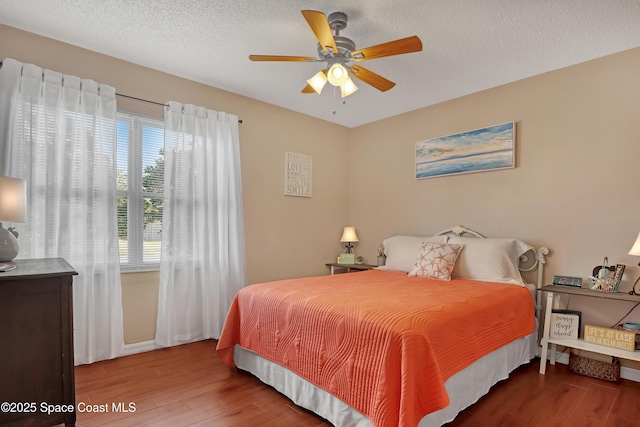 bedroom featuring a textured ceiling, ceiling fan, and hardwood / wood-style flooring