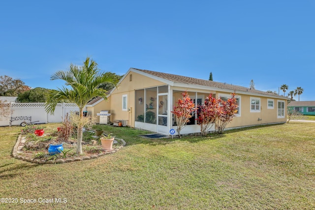 back of property featuring a yard and a sunroom