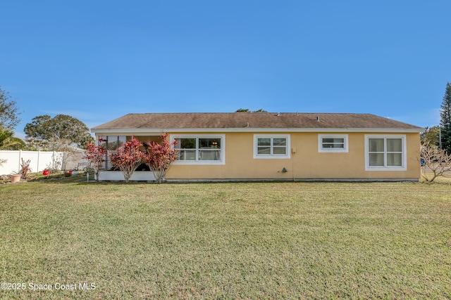 rear view of property featuring a lawn