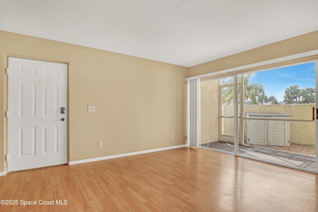 unfurnished room featuring wood-type flooring and a textured ceiling