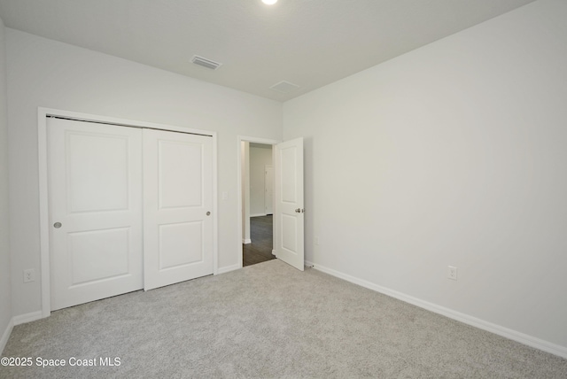 unfurnished bedroom featuring light colored carpet and a closet