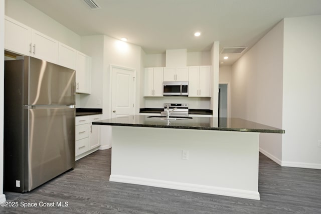 kitchen with a center island with sink, stainless steel fridge, and white cabinetry