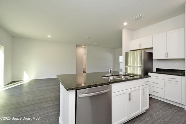 kitchen with appliances with stainless steel finishes, white cabinetry, a kitchen island with sink, and sink