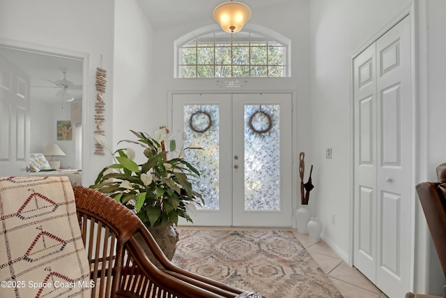 entryway with ceiling fan, light tile patterned flooring, and french doors