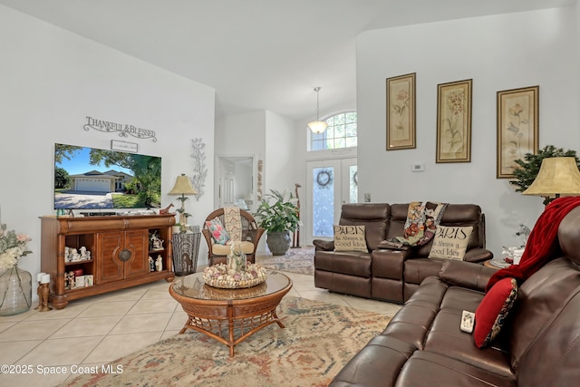 tiled living room featuring high vaulted ceiling and french doors