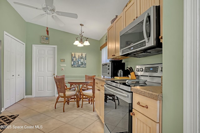 kitchen featuring light brown cabinets, hanging light fixtures, lofted ceiling, light tile patterned flooring, and appliances with stainless steel finishes