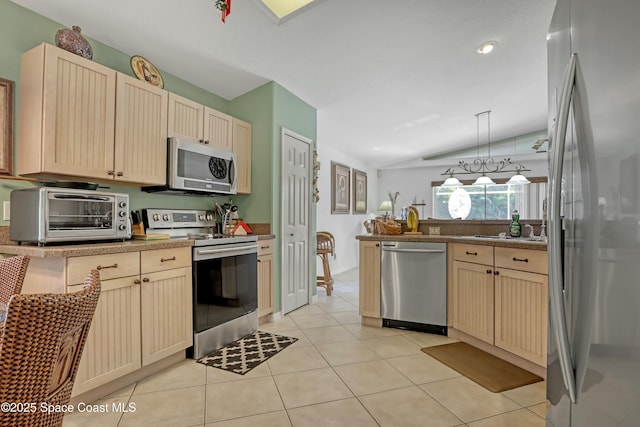 kitchen featuring light brown cabinetry, stainless steel appliances, vaulted ceiling, light tile patterned floors, and hanging light fixtures