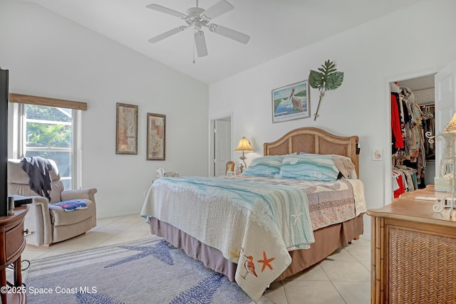 tiled bedroom with a walk in closet, a closet, vaulted ceiling, and ceiling fan