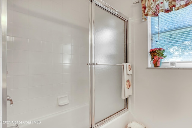 bathroom featuring bath / shower combo with glass door