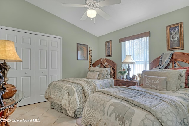 bedroom with ceiling fan, lofted ceiling, light tile patterned floors, and a closet