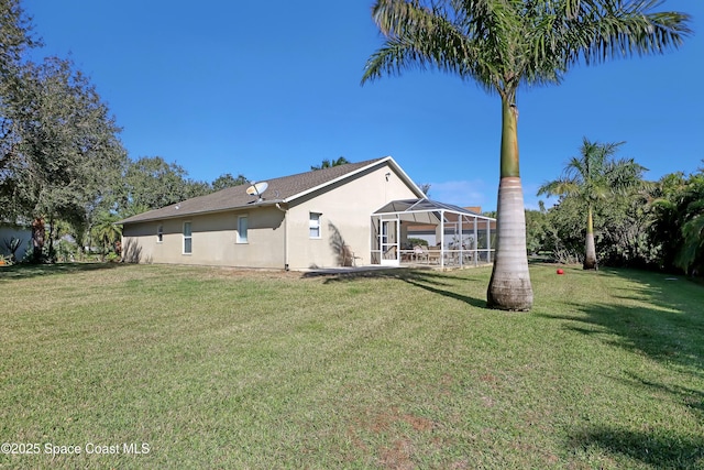 back of house with a lanai, a yard, and a patio