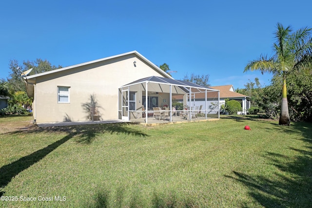 rear view of property featuring a lanai, a patio area, and a yard