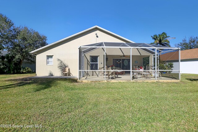 back of house featuring a yard, a patio area, and a lanai