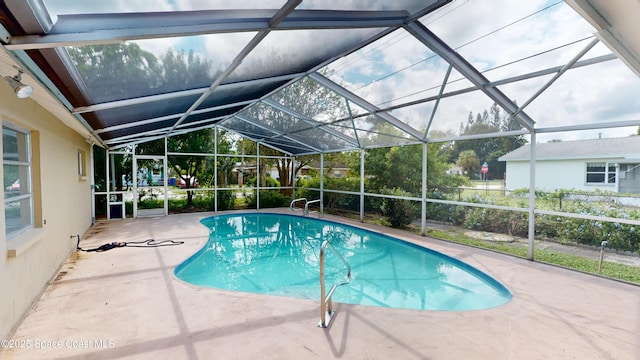 view of pool with glass enclosure and a patio