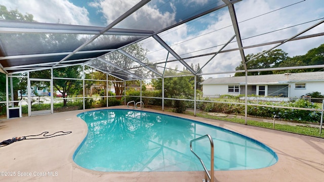 view of pool with glass enclosure and a patio