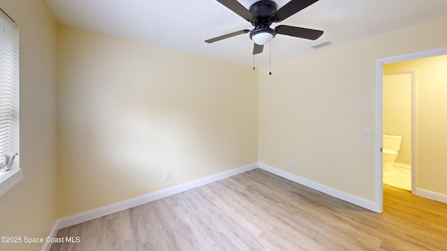 spare room with ceiling fan and light wood-type flooring