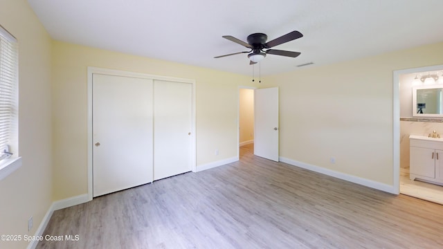 unfurnished bedroom with ensuite bath, ceiling fan, sink, light hardwood / wood-style floors, and a closet