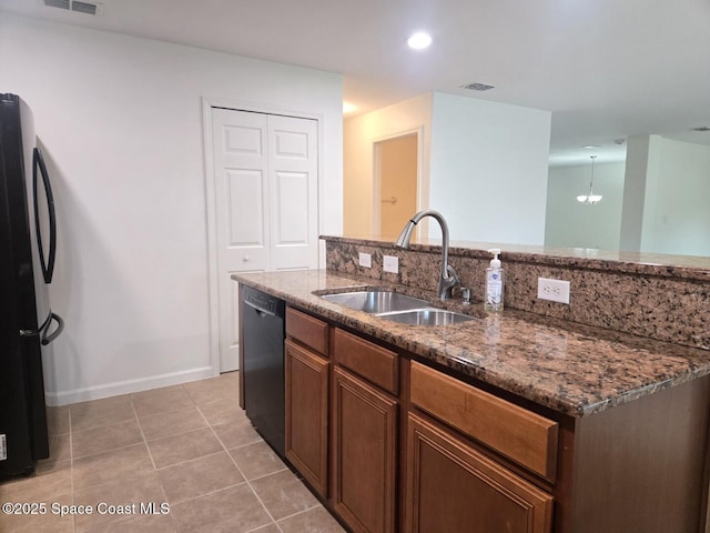 kitchen with dark stone counters, an inviting chandelier, black appliances, sink, and light tile patterned floors