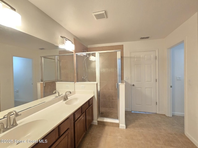 bathroom featuring tile patterned flooring, vanity, and a shower with shower door