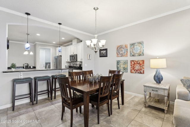 dining room with light tile patterned floors, ornamental molding, and a chandelier