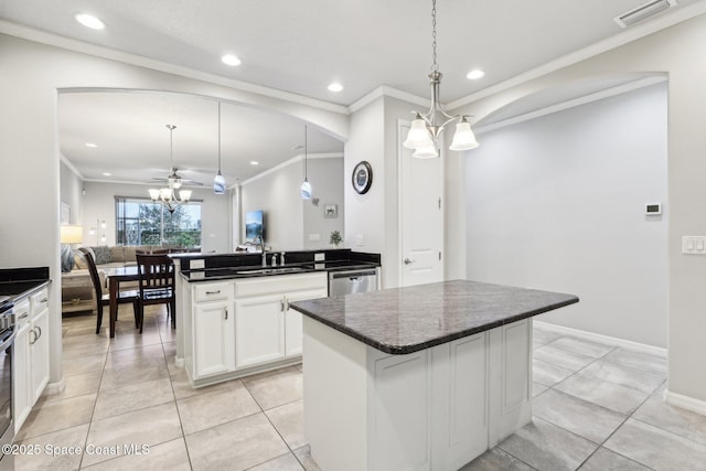 kitchen with decorative light fixtures, white cabinets, ceiling fan with notable chandelier, and a kitchen island