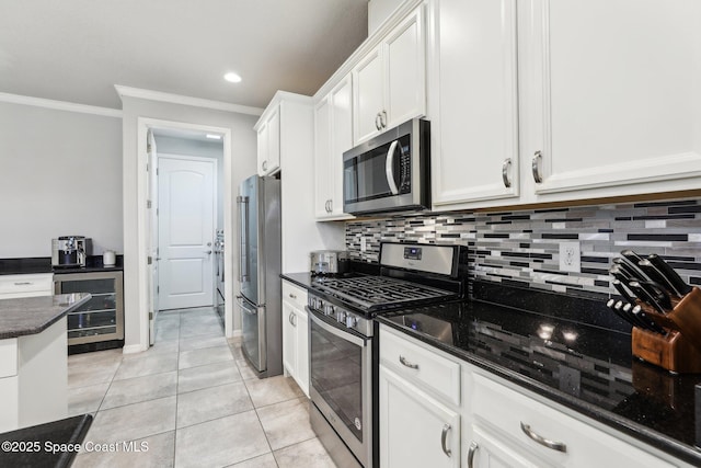 kitchen featuring light tile patterned floors, white cabinetry, stainless steel appliances, wine cooler, and ornamental molding