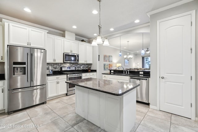 kitchen with pendant lighting, white cabinets, stainless steel appliances, sink, and crown molding