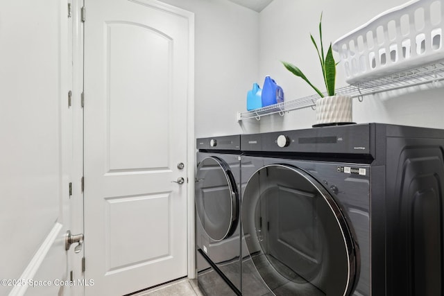 laundry room with washing machine and dryer and light tile patterned flooring