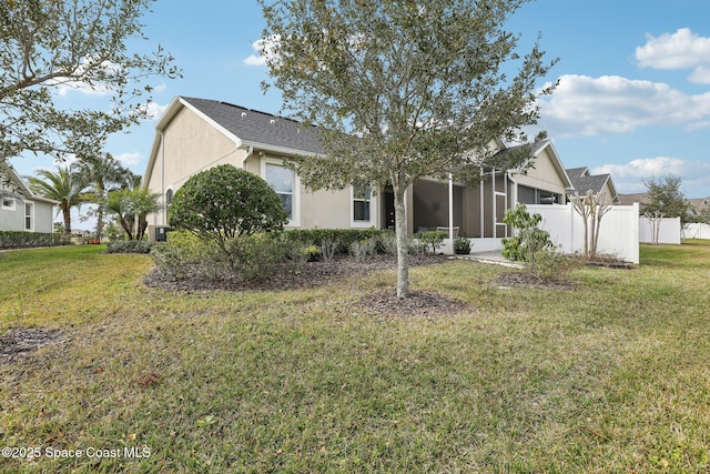 back of property featuring a yard and a sunroom